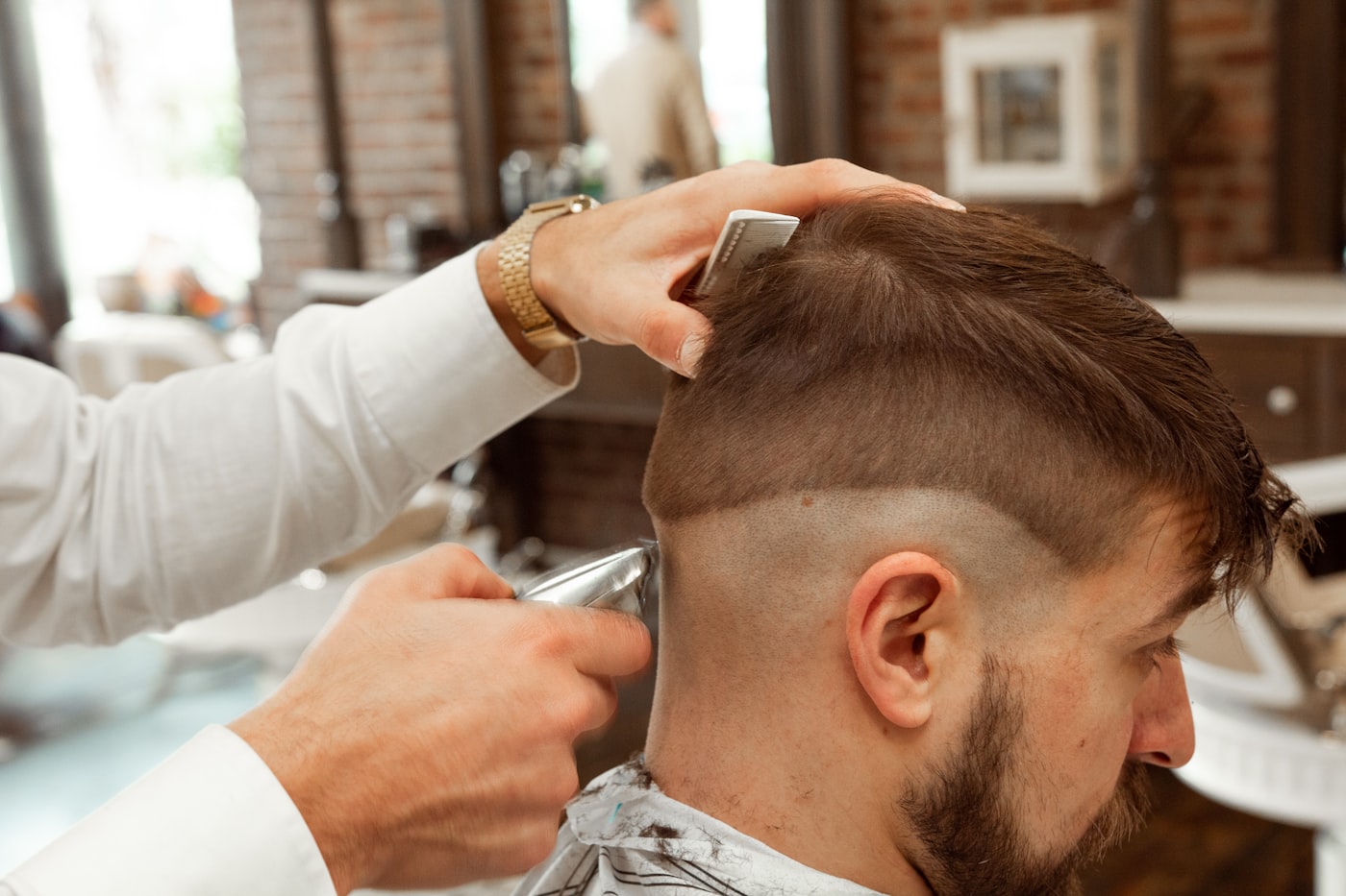 Barber giving a client a precise fade haircut