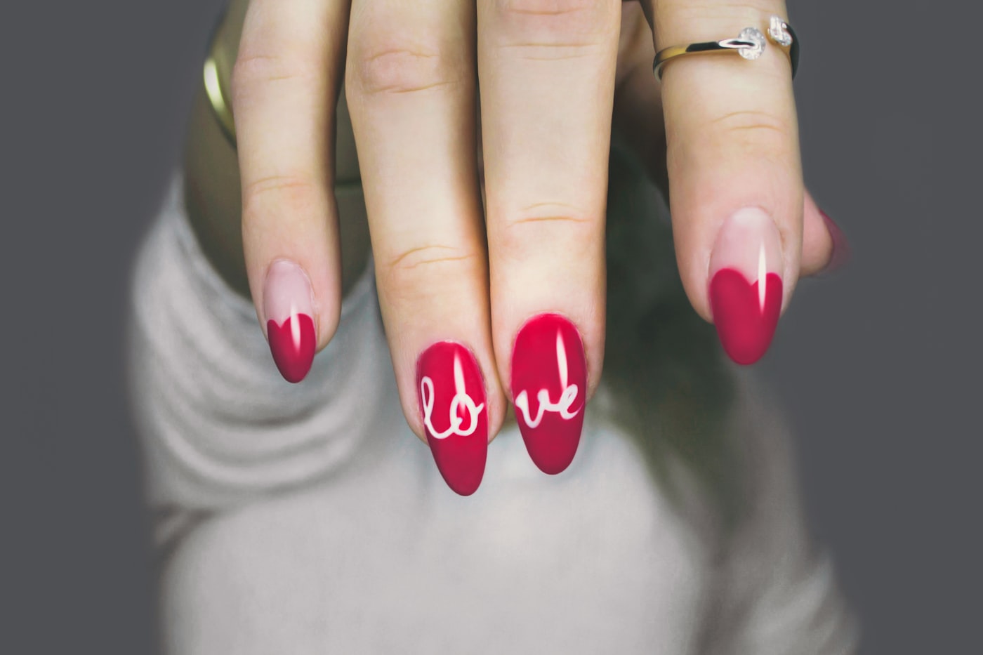 Close-up of vivid red manicured nails with hand-painted art